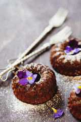Delicious chocolate ring cake decorated with fresh violets