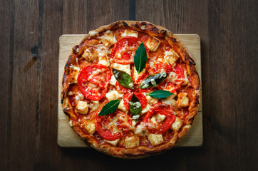 Pizza on wood table, top view.