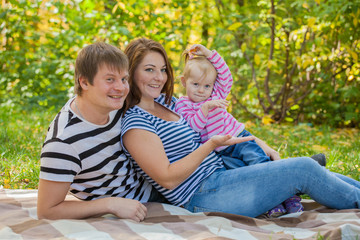 Fototapeta premium happy family in autumn park in the same dress at a picnic