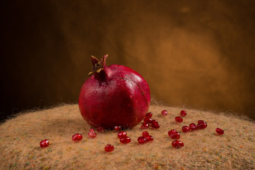 Pomegranate slices and garnet fruit seeds on table.
