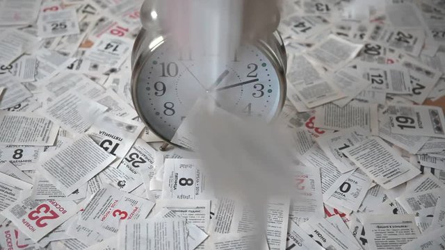 The falling leaves of the calendar tear-off calendar and a large clock