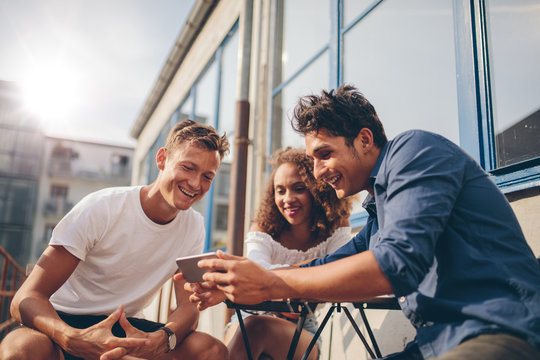 Group of friends watching video on smartphone