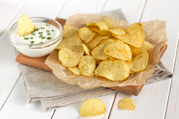 Potato chips on a parchment on a table.