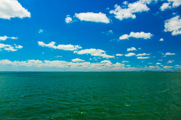 Obraz premium Blue sky with clouds and green sea