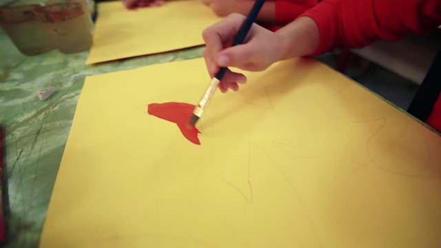 The girl draws a picture paints in classroom