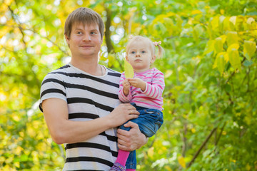 young father with a daughter in autumn park
