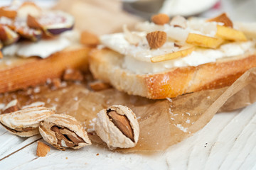 Bruschetta with goat cheese, pear and almond nuts on parchment