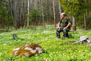 Springtime is the moment for flower. Snowdrop anemone. man with an ax sitting on a bench in the form of hunting