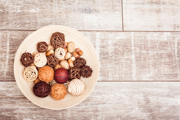 Autumn plate with oak acorns, wicker balls on wooden background. Copy space at right. 