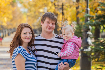 Fototapeta premium happy family in the same clothes for a walk in the park in autumn