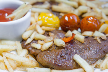Vegetarian steak made from vegan seitan, cherry tomatoes and fries
