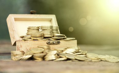 Golden money coins in a wooden box - fortune, lottery win concept