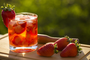 Fresh made Strawberry Caipirinha on green blurry background
