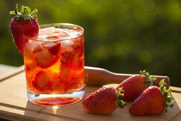 Fresh made Strawberry Caipirinha on green blurry background