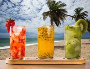 Three drinks made with passion fruit, strawberry and kiwi Caipir