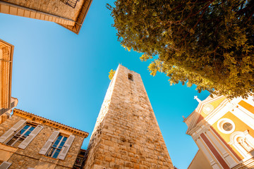 Central square with tower and church in Antibes coastal village on the french riviera in France
