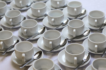 Obraz na płótnie Canvas white cup on a saucer and a spoon are put in a row.Catering food