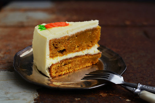 Piece of homemade carrot cake on rustic dark background