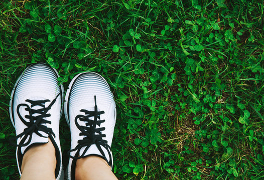 Sports shoes sneakers, ball and bottle of water on a fresh green grass