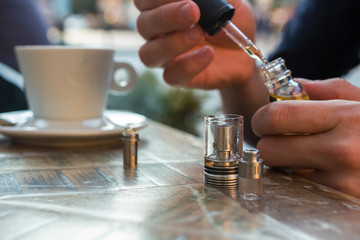 Man filling an electronic cigarette or vaporizer with e-liquid 