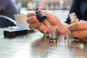 Man filling an electronic cigarette or vaporizer with e-liquid 