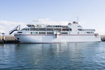 White auto ferry lying at the jetty with blue skies and turquois