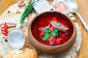 Traditional Ukrainian Russian vegetable soup, borsch with garlic donuts, pampushki on a white wooden background.