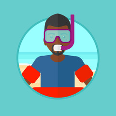 Man with snorkeling equipment on the beach.