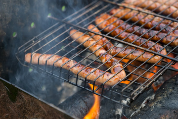 Picnic in nature with german sausages on the grill