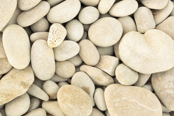 small pebbles piled next to a beach. Horizontal capture with warm tones.