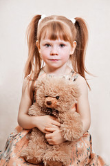 girl with red hair playing with teddy bears