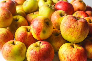 Green and red organic apples are on the table.