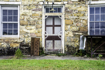front screen door entrance to abandon stone building