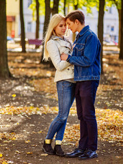 Fototapeta premium Man and woman hugging and flirting in autumn park .Young people dressed in denim walking in autumn park.