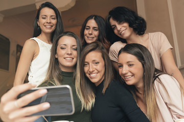 Friends taking a photo with a phone.