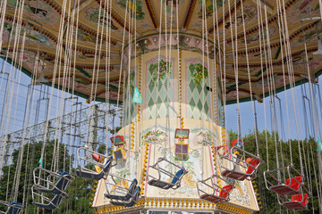 colored chairoplanes against a blue sky in an amusement park