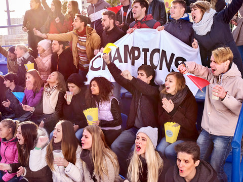 Sport fans holding champion banner and eating popcorn on tribunes. Group people.