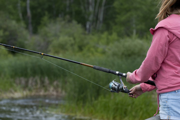 Mid section view of a girl fishing, Riding Mountain National Par