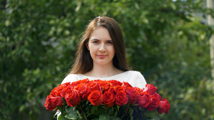 woman holding a bouquet of roses outdoors