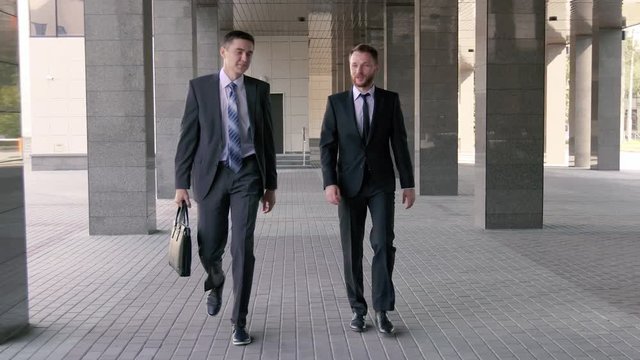 Two young businessmen walking to the office together