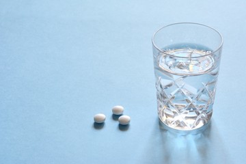 白色の錠剤と水　水色背景
