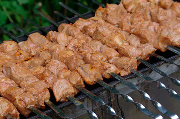 Shashlik on skewers closeup, raw and cooked