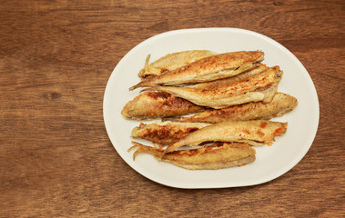 Lot of small fried fish in breadcrumbs