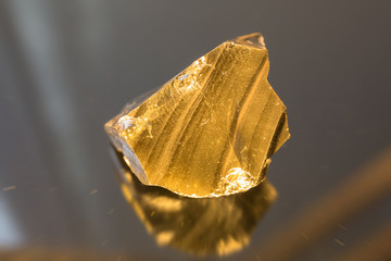 Radial blurred background view of volcanic glass mineral under sun light on black background