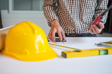 Modern architect looking at blueprint with sketch