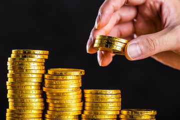 金貨を積み上げる人の手