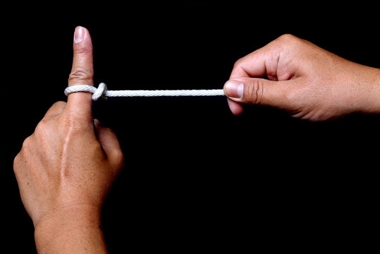 Two hands pulling a rope in opposite directions, isolated on black background