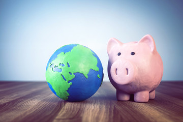 3d Sparschwein mit Erdkugel aus Knetmasse, erklärt die Finanzwirtschaft auf der Welt