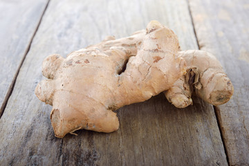 whole raw ginger on wooden table