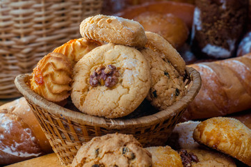Freshly baked cookies and sweet pastries in the basket on wooden table